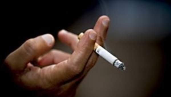 Mano con cigarrillo encendido Mano con cigarrillo encendido